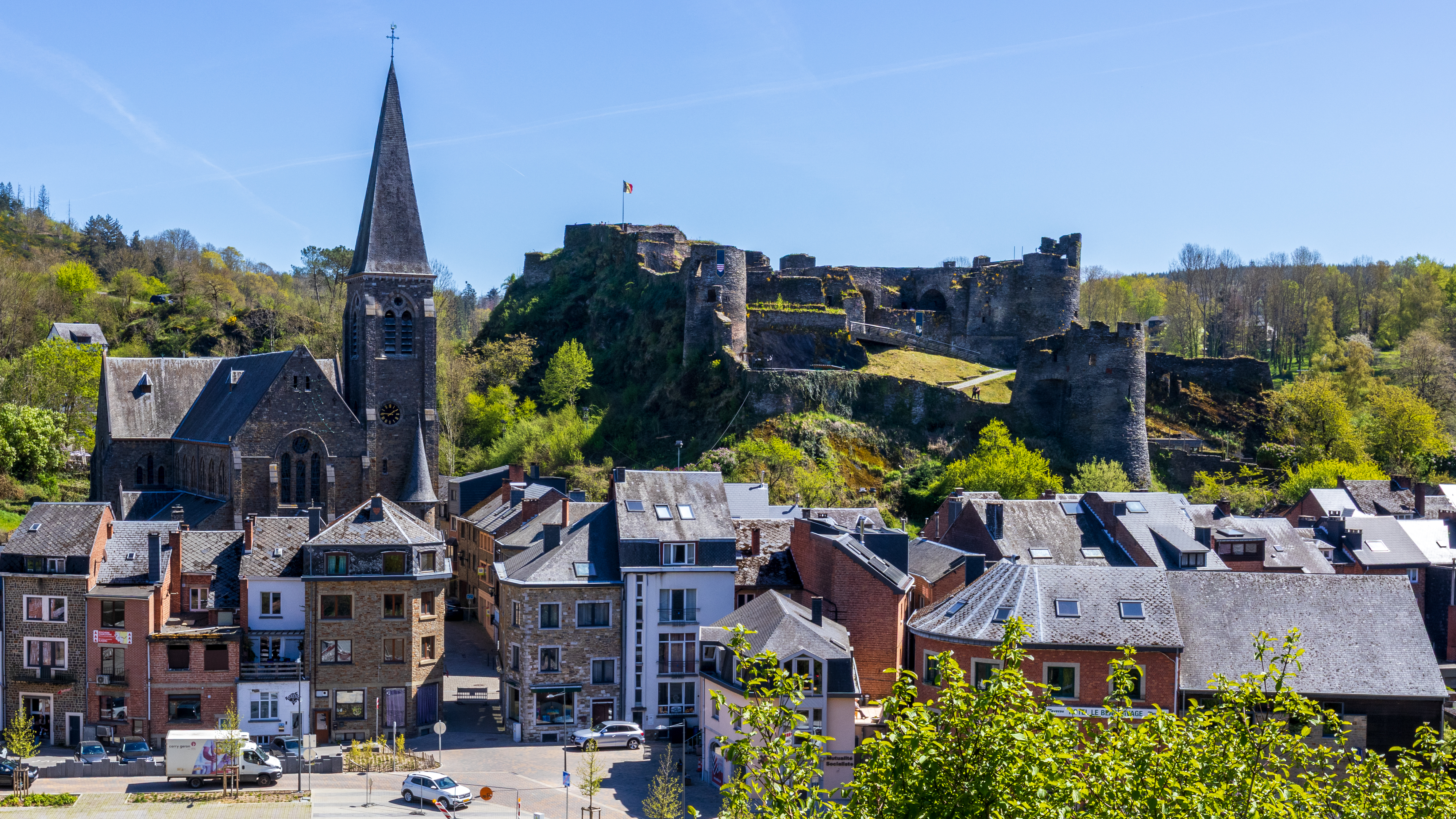 La Roche-en-Ardenne feudal castle ruins and Saint-Nicolas church against the Ardennes skyline, Belgium