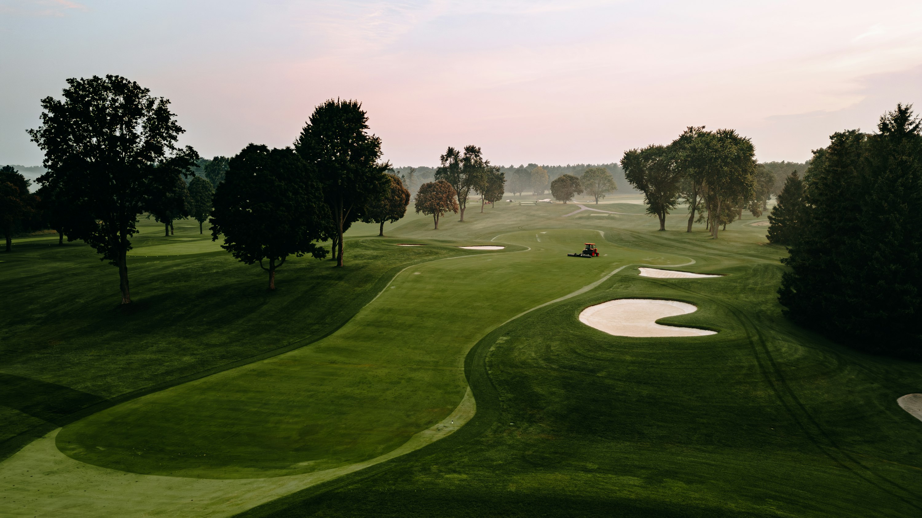 A golf course surrounded by mature trees