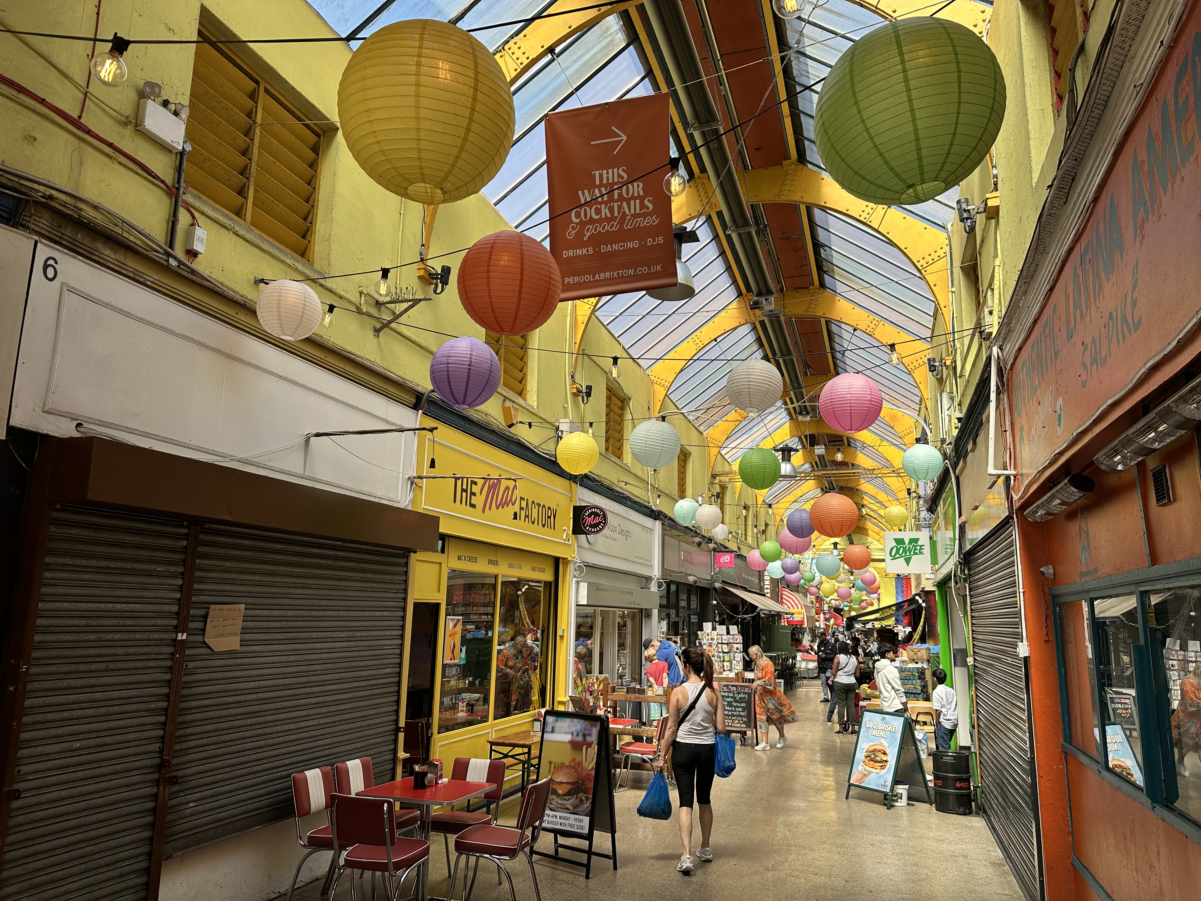 Inside Brixton Village, the covered market arcade in SW9, looking down the central passage