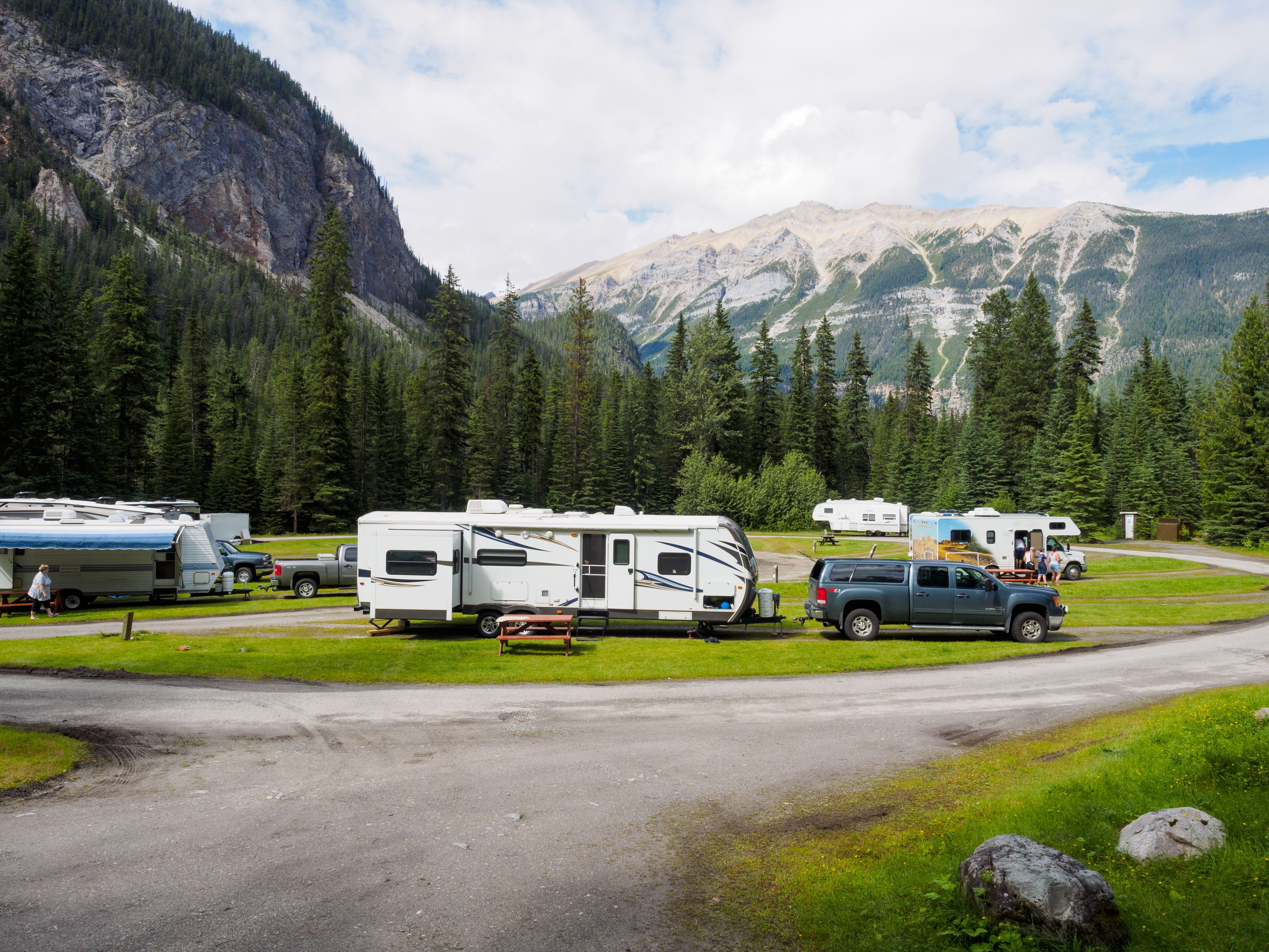 Motorhomes and trailers at a forested campsite